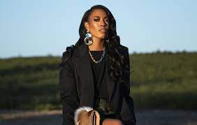 image of Shelby Ivey Christie dressed in black business attire posing for the camera outside