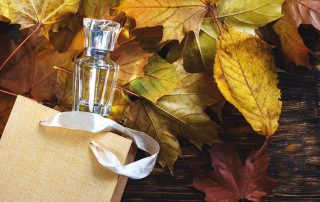 best fall fragrances - bottle of women's perfume on a fall background