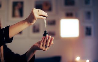 woman putting perfume in her hand at bedtime