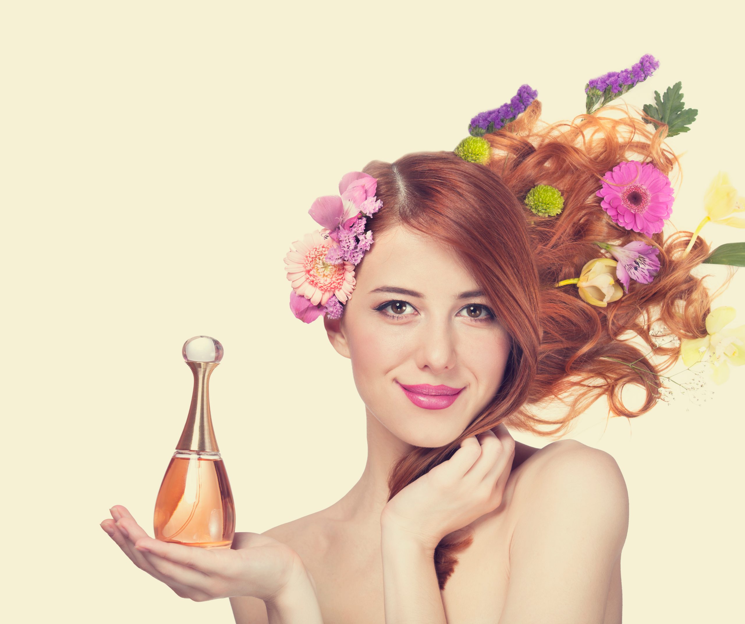 woman holding perfume with bright colors surrounding her