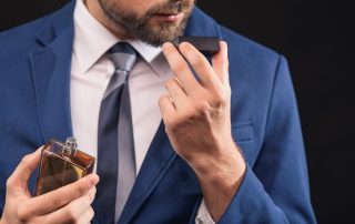 man in a blue suit smelling cologne