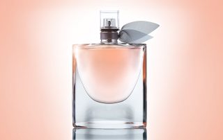 bottle of sheer perfume on a pink background
