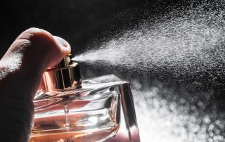 spraying perfume on dark background