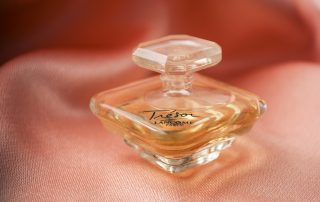 bottle image of Lancome Tresor sitting on a pink satin sheet